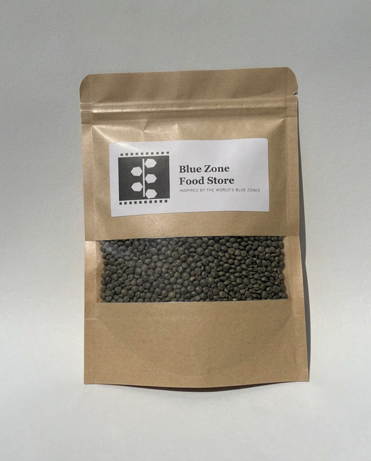 Dried Green Lentils in a kraft stand-up pouch with a clear window, Blue Zone Food Store label, on a light grey studio background
